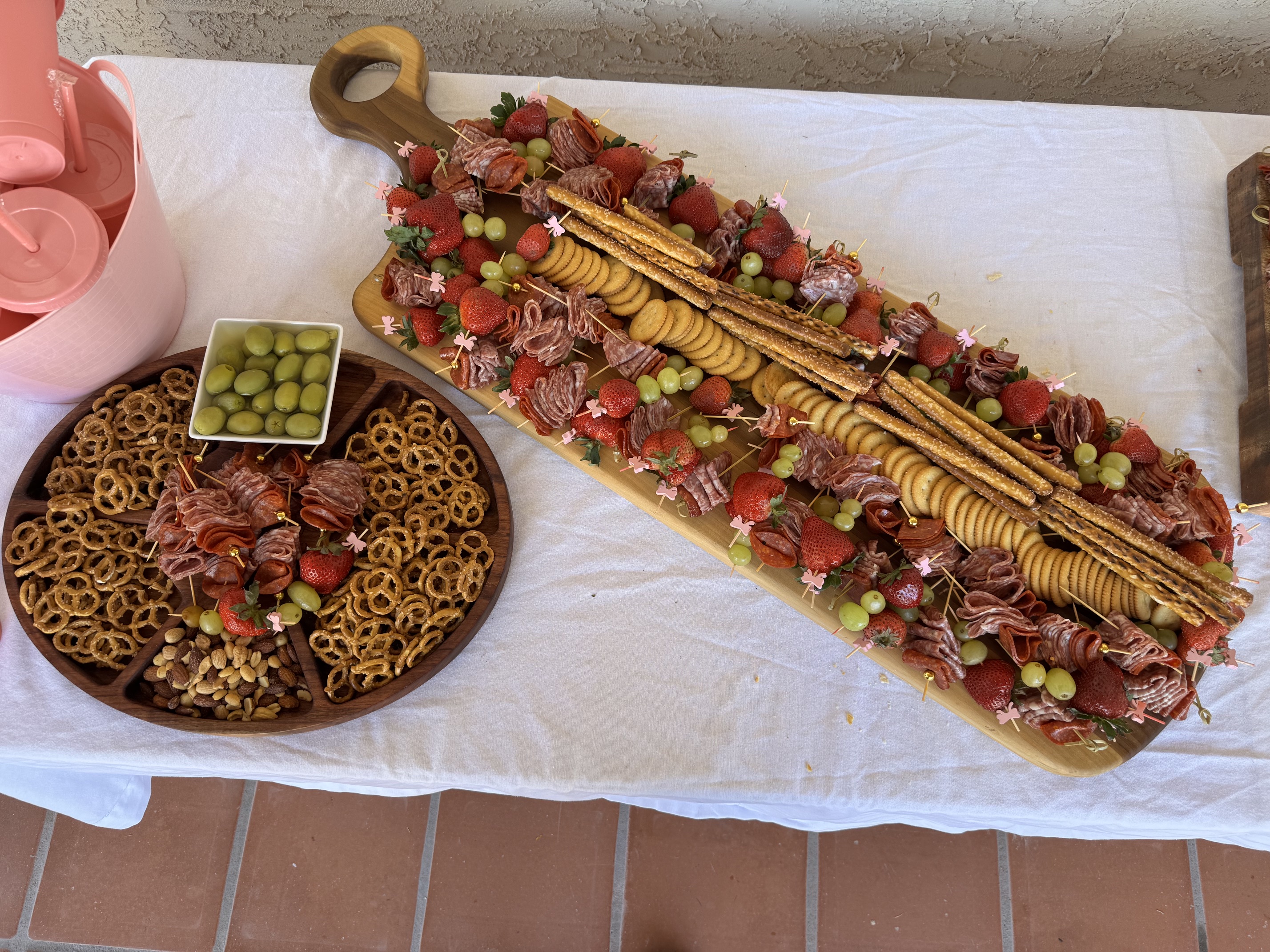Ejemplo de uso: mesa larga de madera con embutidos, fresas, uvas y galletas para un evento.