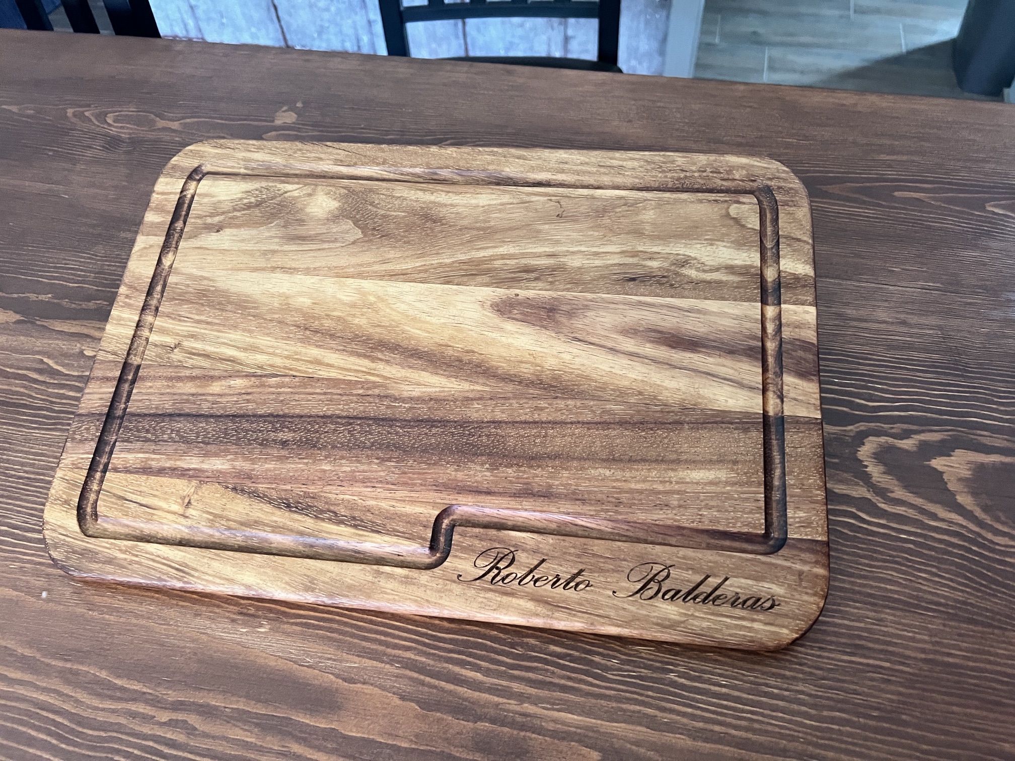 Tabla de madera grabada con el nombre 'Roberto Balderas' en letra cursiva.